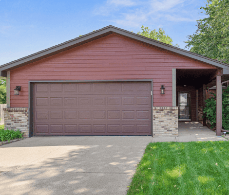 Single-story house with brown garage and green lawn.