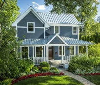 Charming blue house with lush garden and porch.