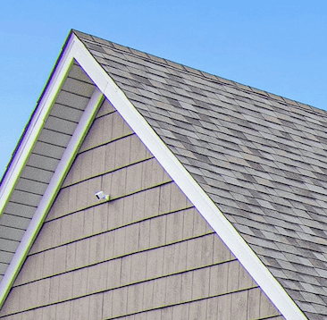 Gabled roof with grey shingles against blue sky.