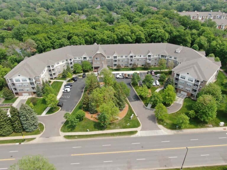 Aerial view of large apartment complex surrounded by trees.