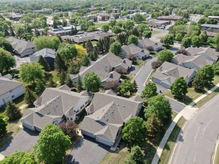 Aerial view of suburban neighborhood with green trees.