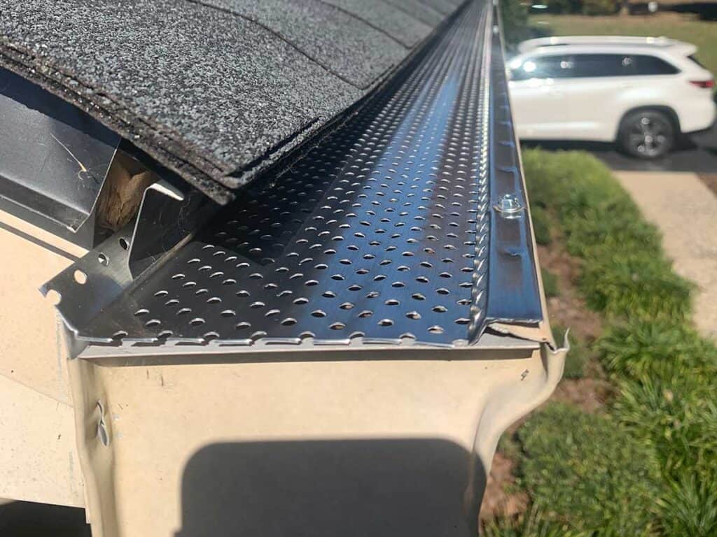 Close-up of perforated metal gutter guard on roof.