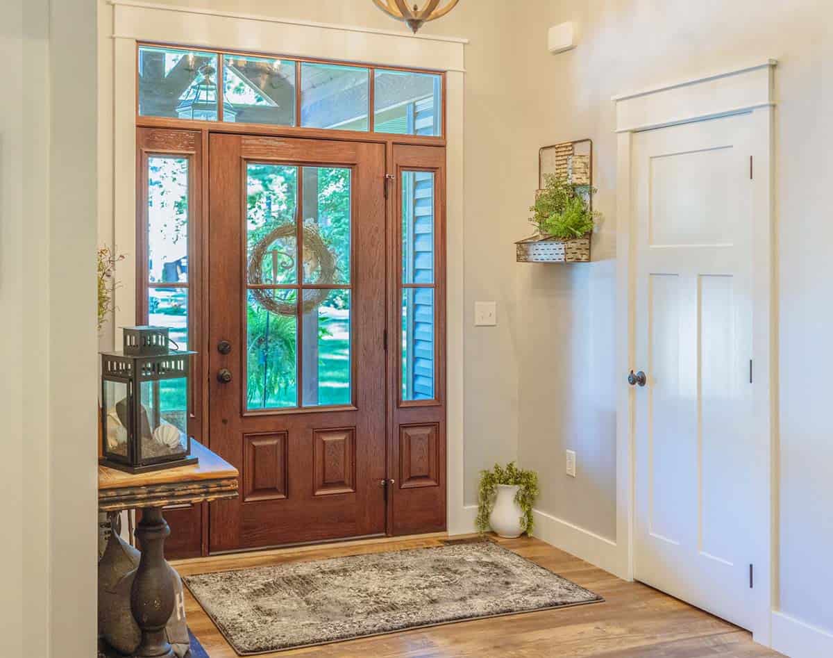 Cozy entryway with wooden door and rug decor.