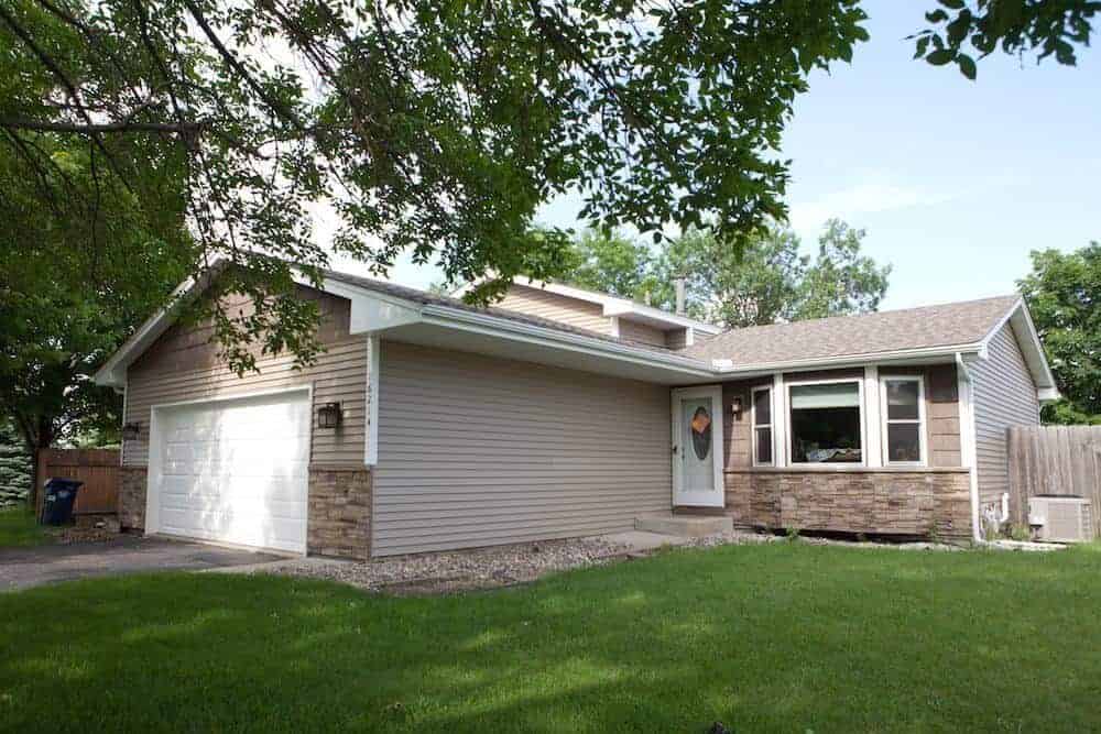 Cozy suburban house with garage and lawn.