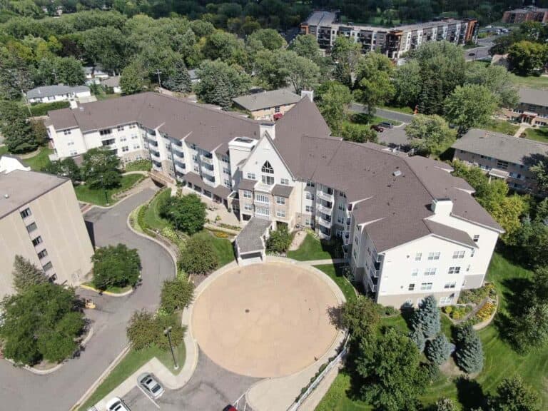 Aerial view of large residential complex surrounded by trees.