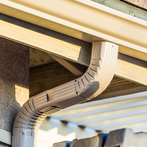 Close-up of house gutter and downspout elbow
