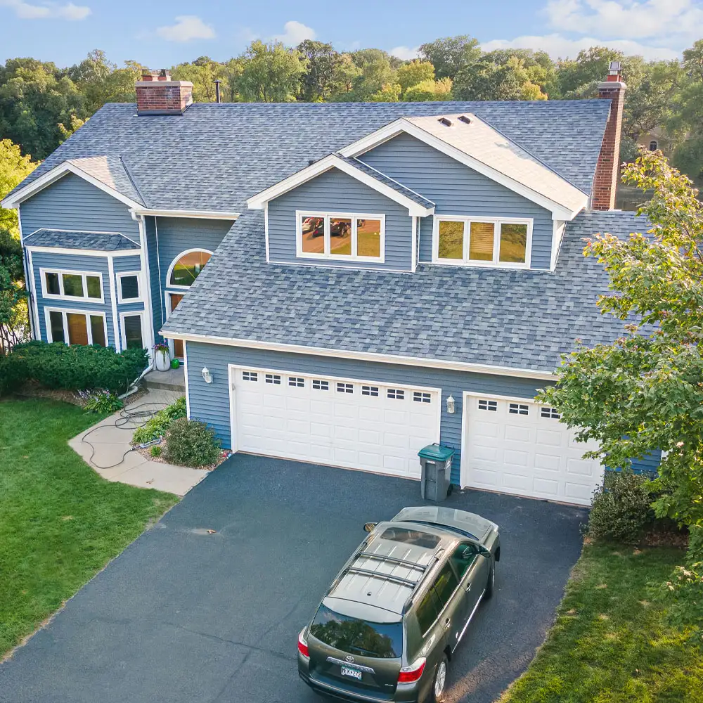 Blue two-story suburban home with three-car garage