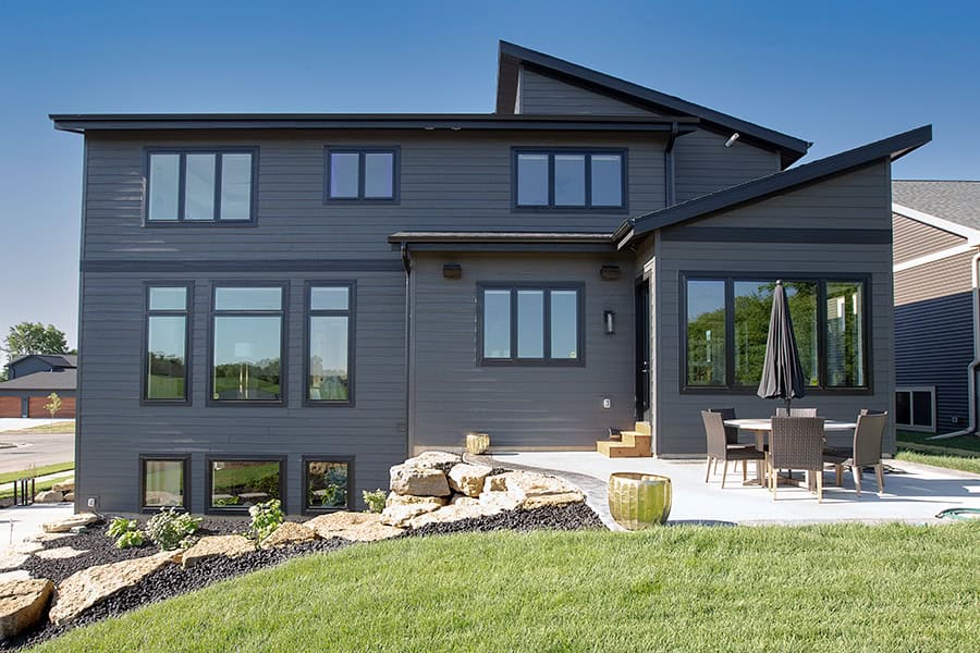 Modern gray two-story home with backyard patio