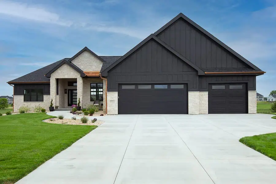 Modern suburban home with three-car garage and lawn