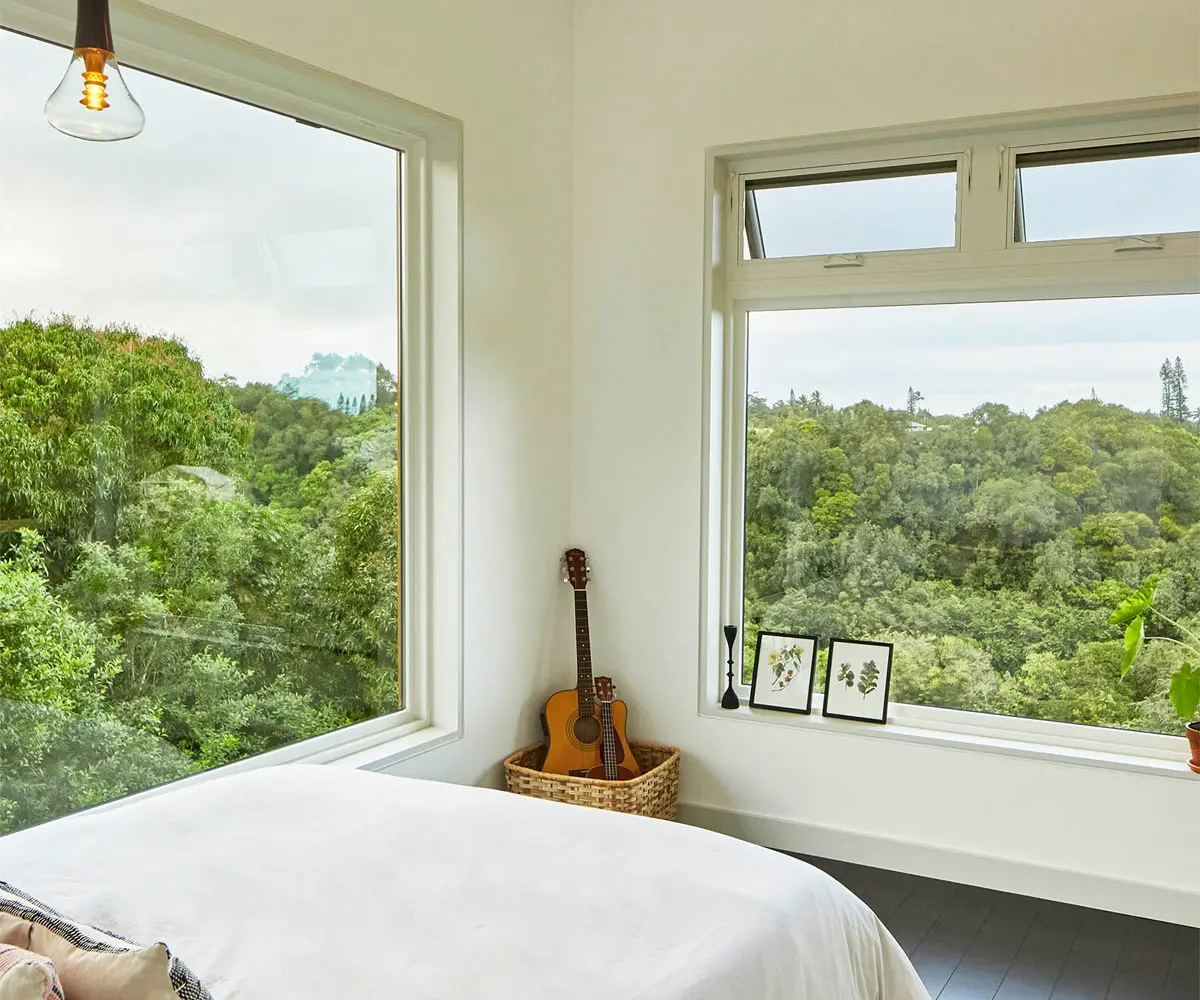 Bright bedroom with forest views and guitar