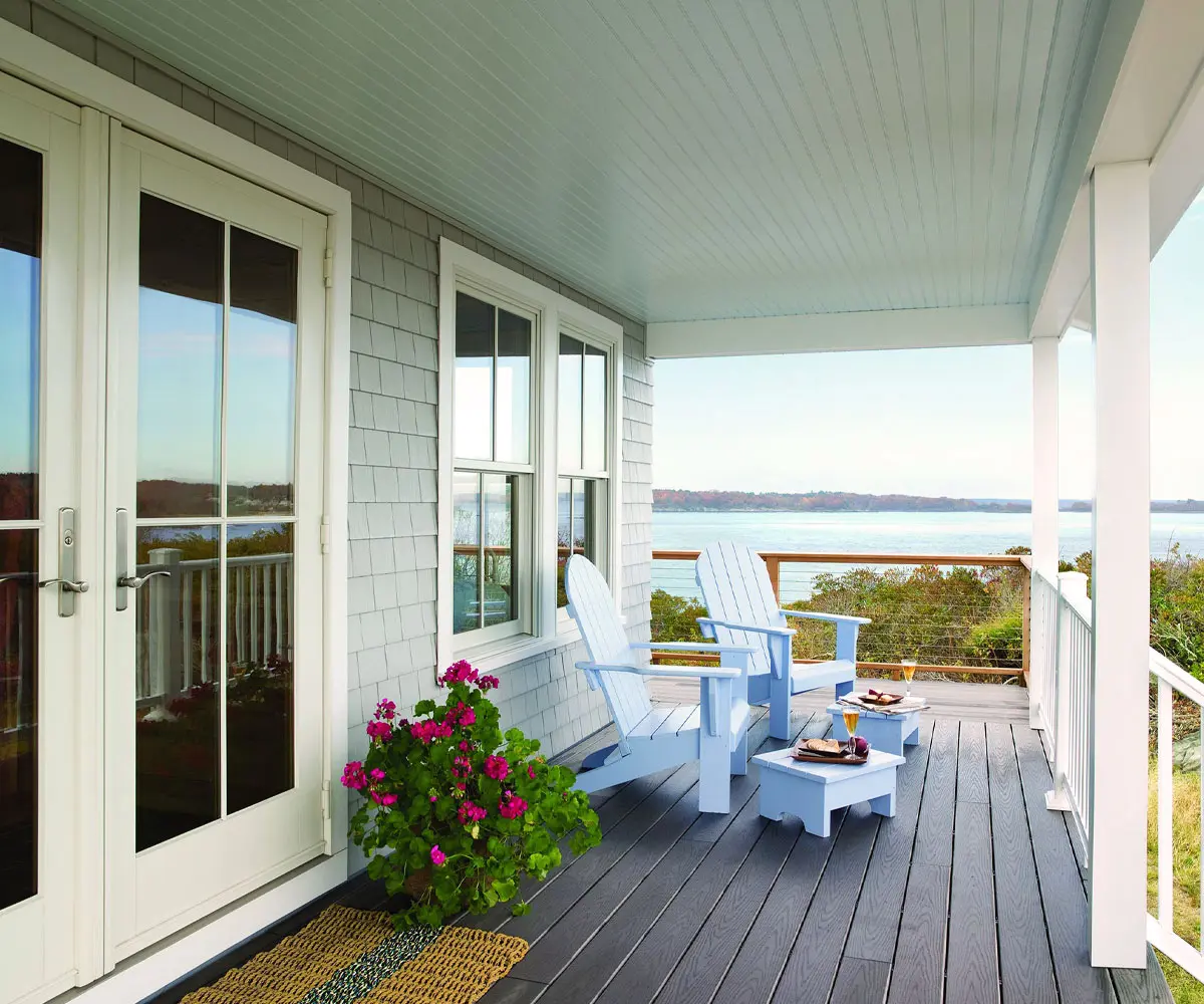 Coastal porch with Adirondack chairs overlooking calm water