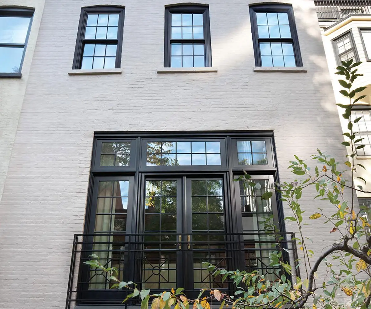 White brick townhouse with black-framed grid windows