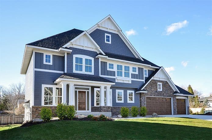 Large blue-gray suburban house with attached three-car garage