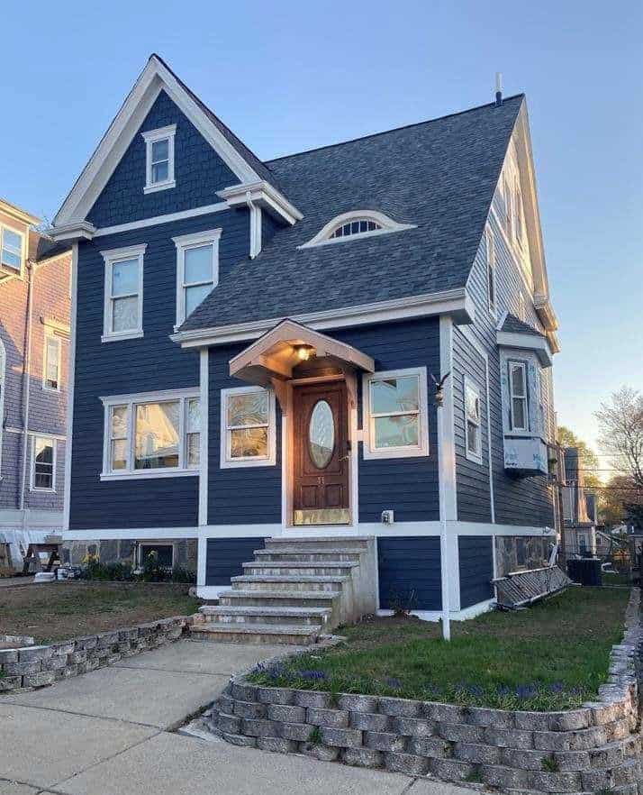 Dark blue two-story house with steep gabled roof