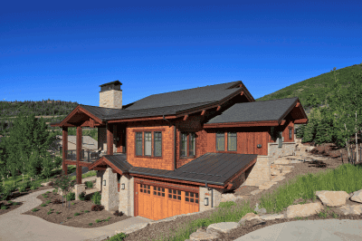 Rustic mountain home with wood siding and stone landscaping
